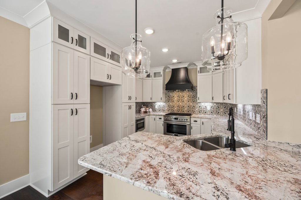 Gourmet kitchen with granite island and custom hood