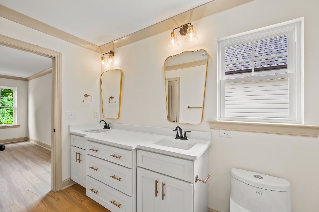 Primary bath vanity with gold mirrors