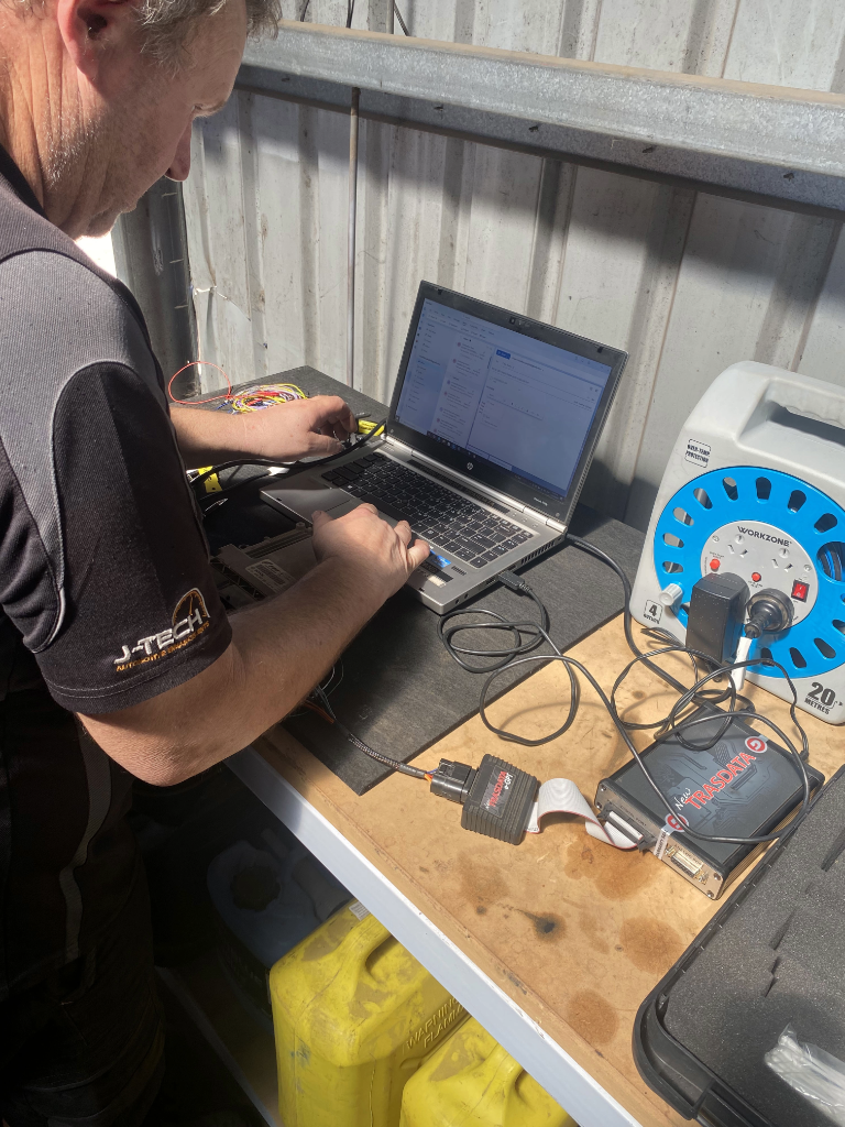 Technician performing ECU benching with specialised bench programming equipment