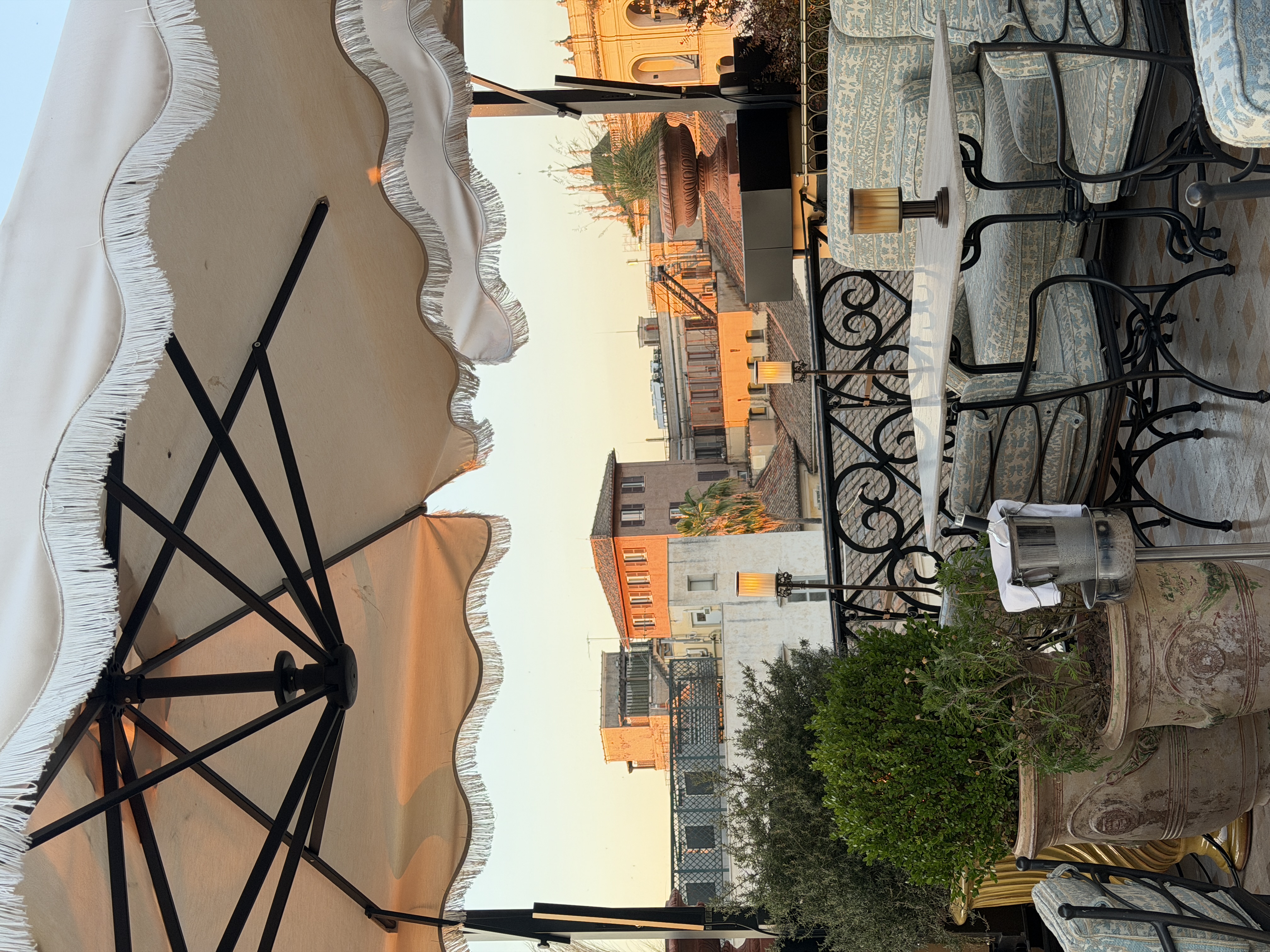 Mediterranean terrace with patio umbrella overlooking a terracotta-roofed cityscape