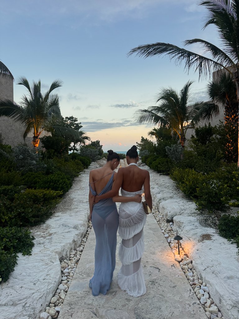 Two women walking together down a stone path at twilight