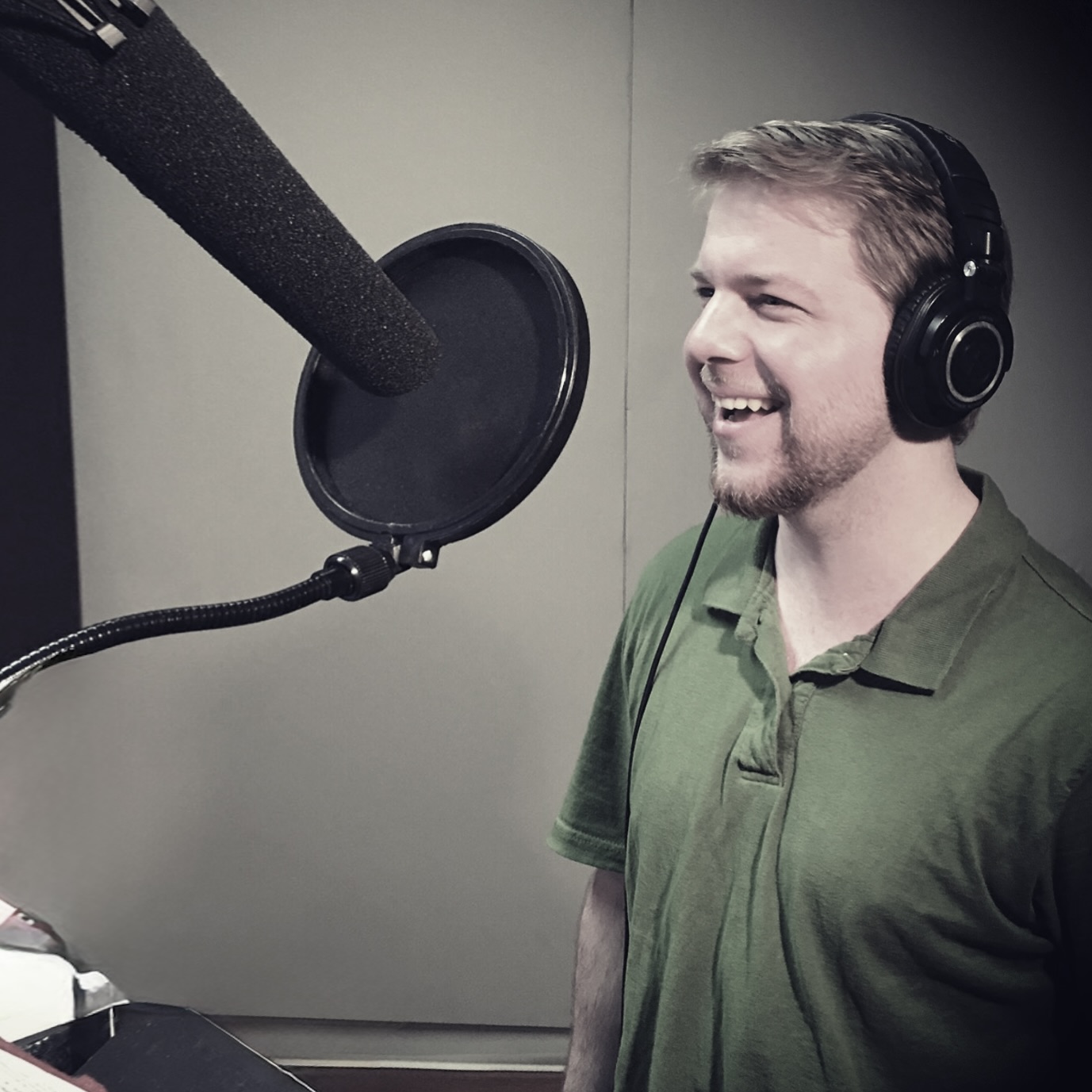 Samuel Fleming recording voice over with headphones and microphone