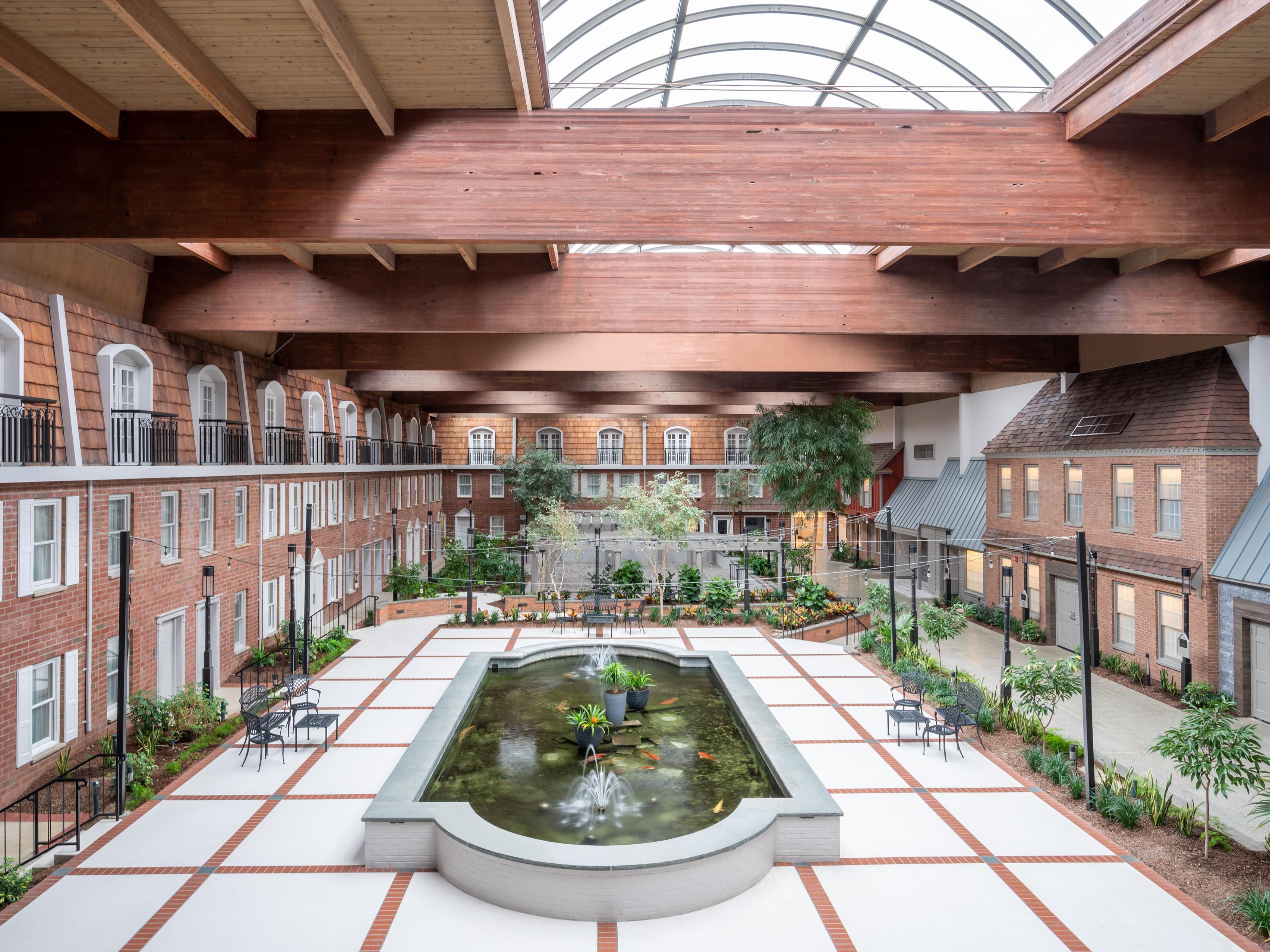 Indoor atrium with glass vaulted ceiling and central fountain