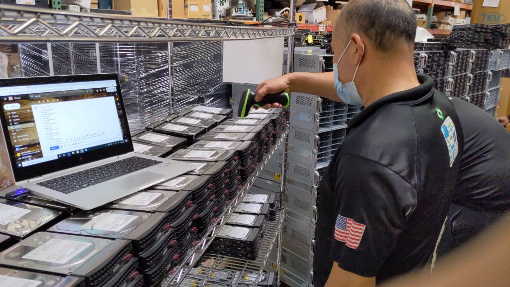 Technician scanning hard drives for inventory tracking