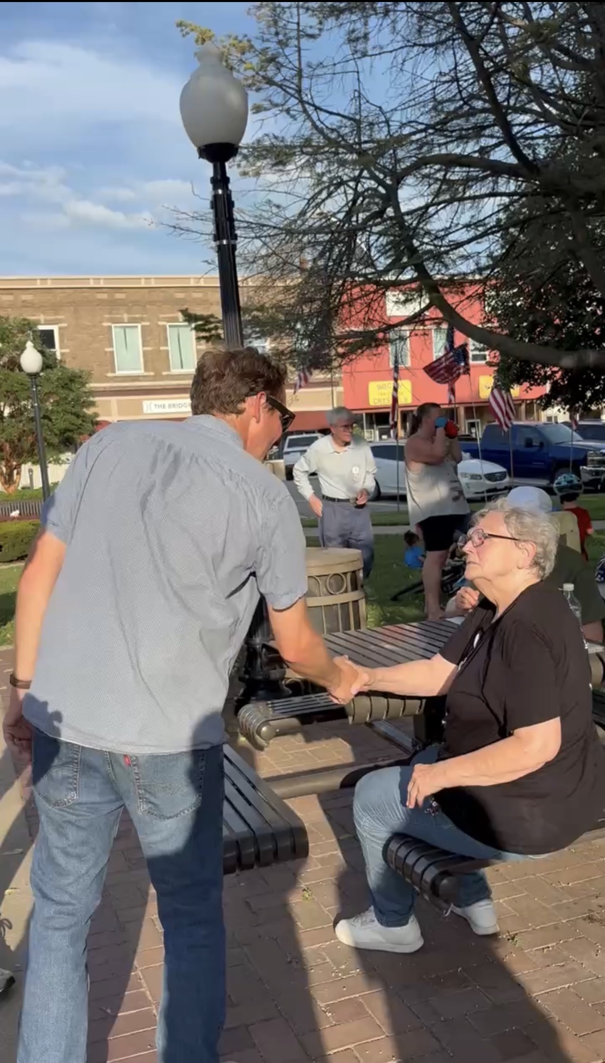 Michael Bridgford shaking hands with a supporter in a town square