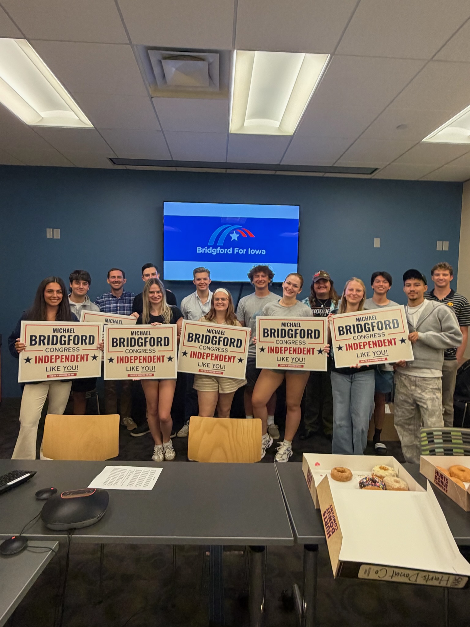 Young adults holding campaign signs indoors