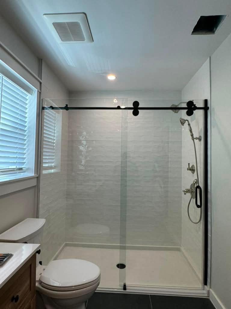 Frameless glass shower door with matte black hardware
