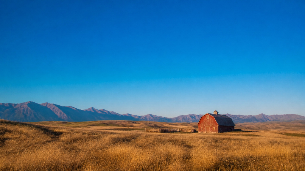 Red barn on vast Montana prairie with mountains in the distance