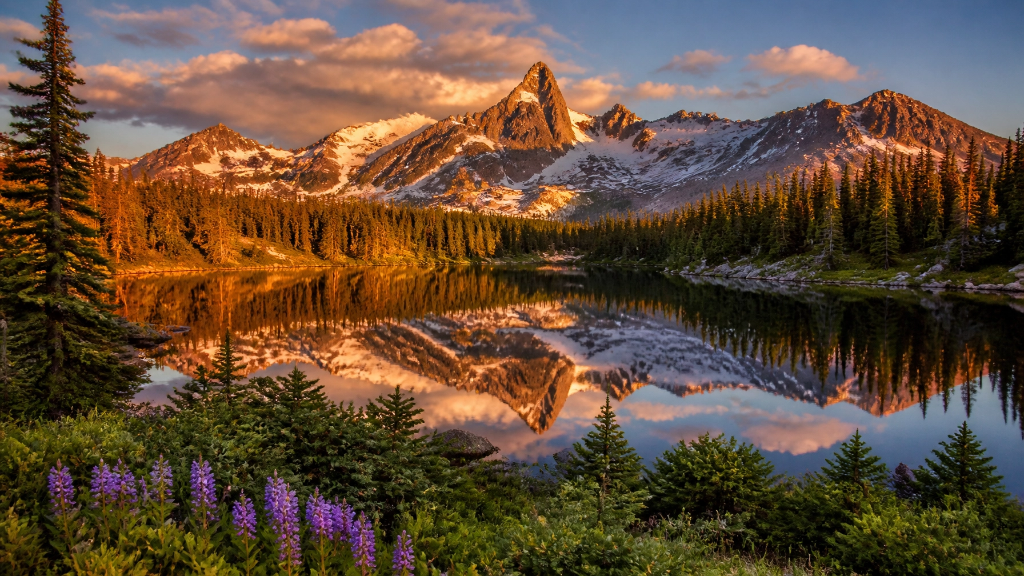 Montana alpine lake with snow-capped peaks and wildflowers