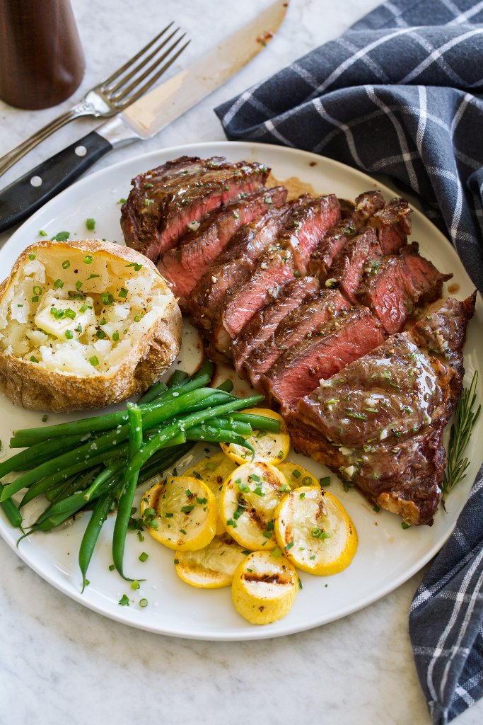 Steak dinner with baked potato and vegetables