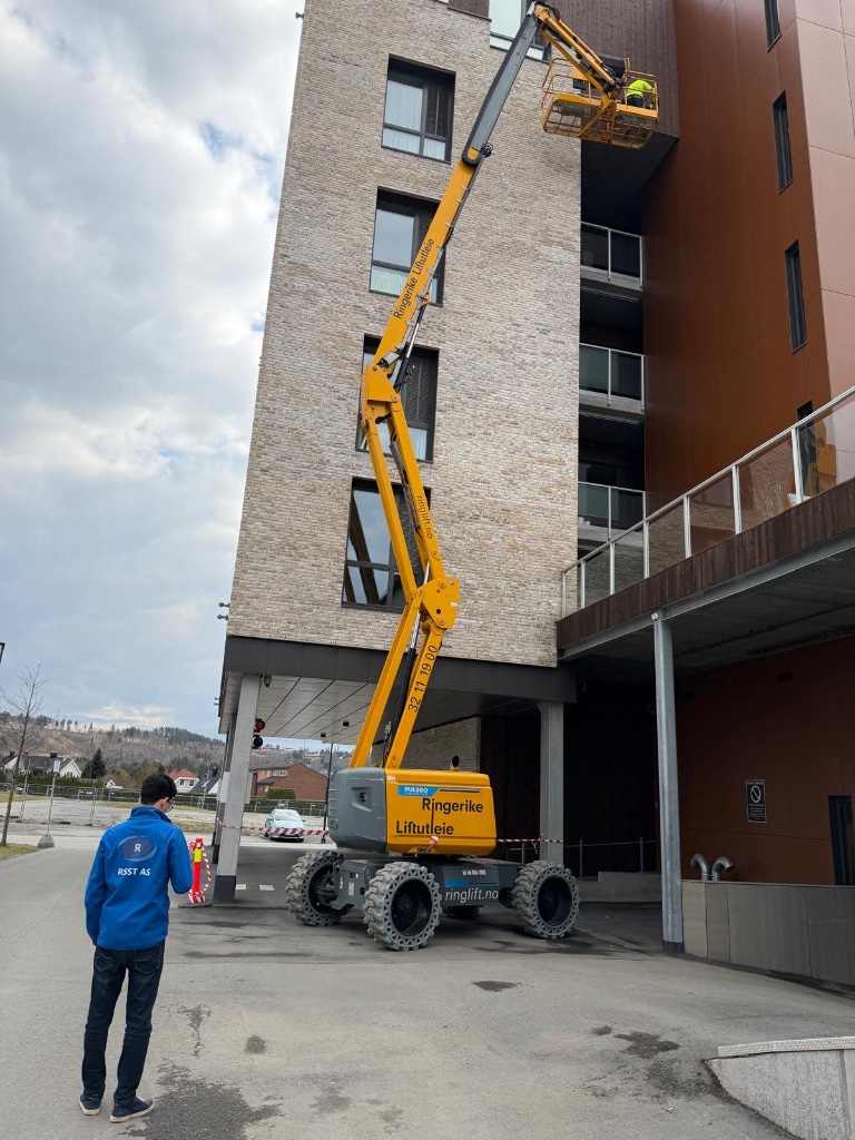 RSST Renhold AS ansatt med lift ved leilighetsblokk