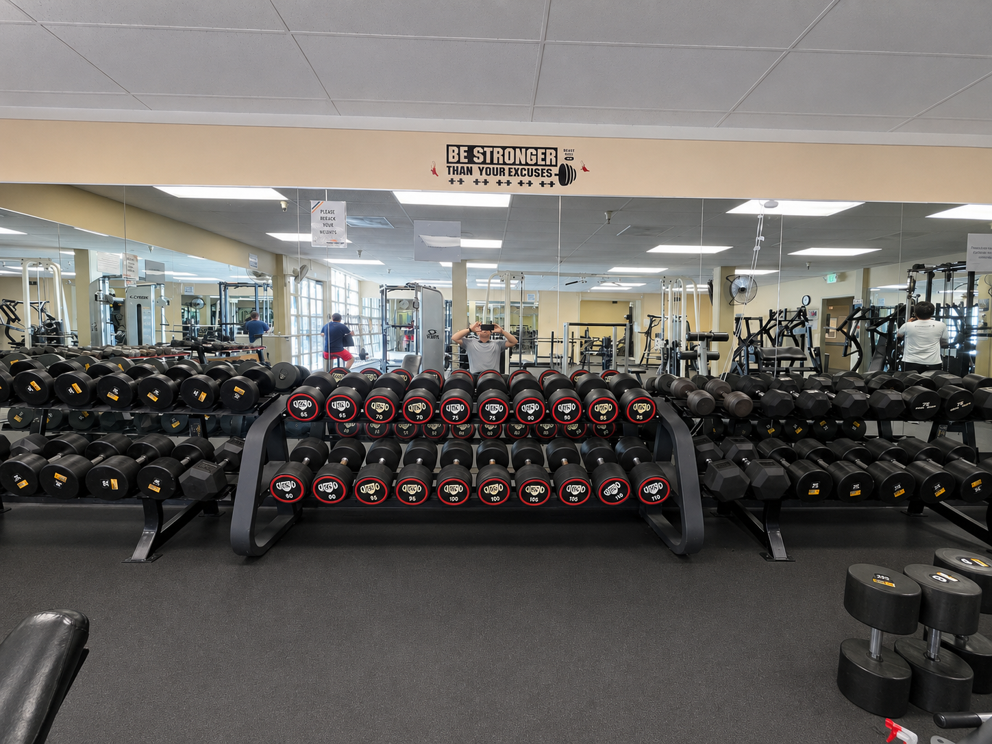 New dumbbells 65–110 lbs on the weight room rack