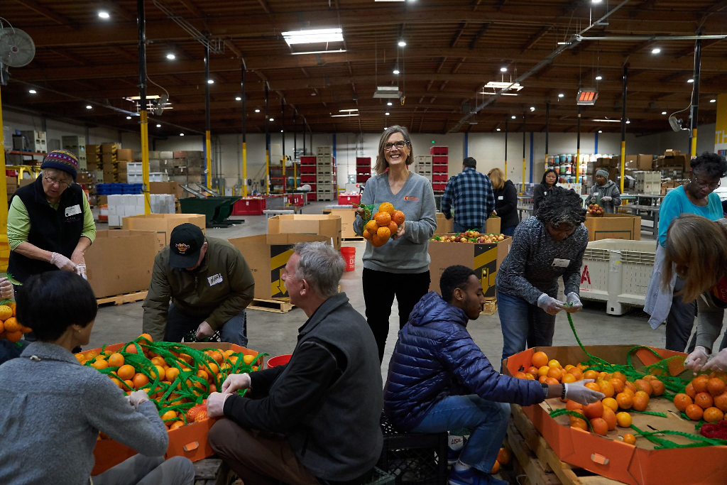 Alameda County Community Food Bank volunteers sorting oranges