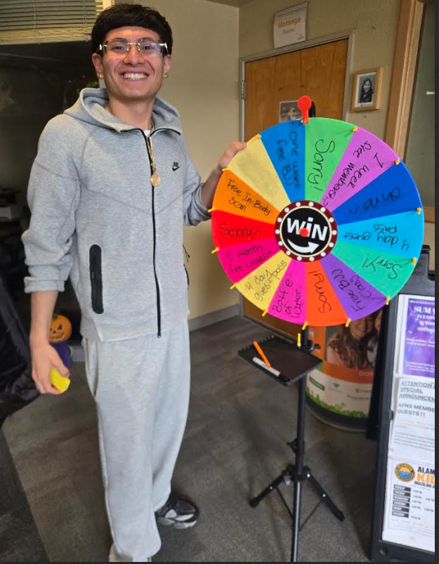 Staff member Fernando Vargas with the Spin the Wheel prize wheel
