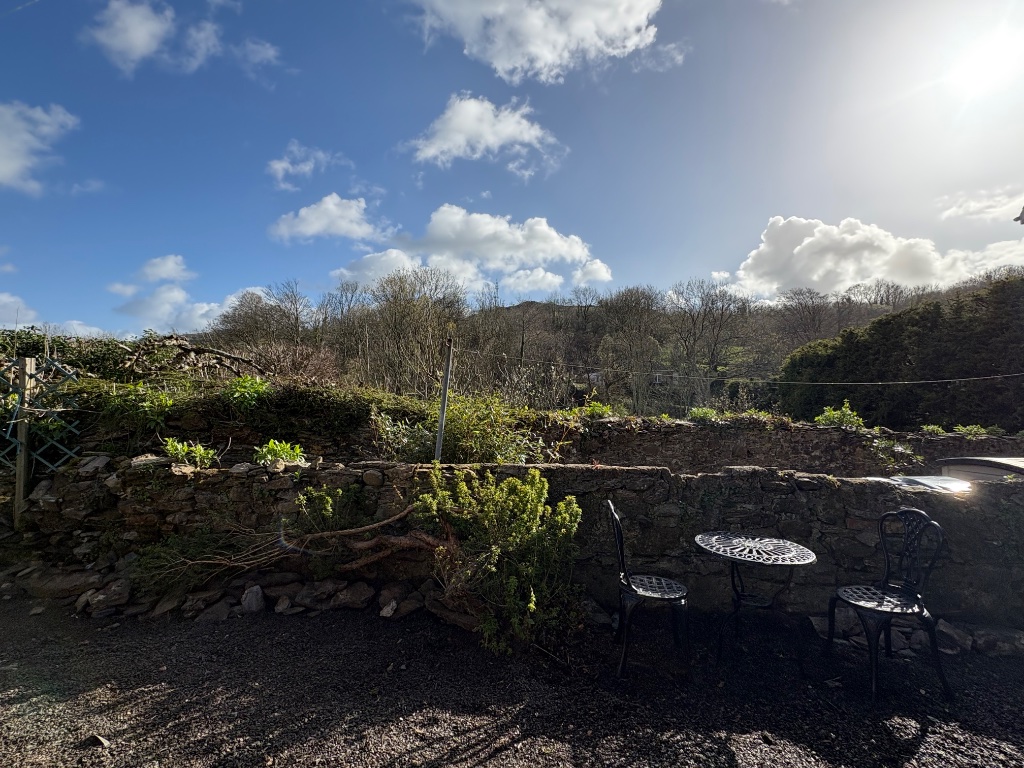 Garden seating area with stone wall and valley views