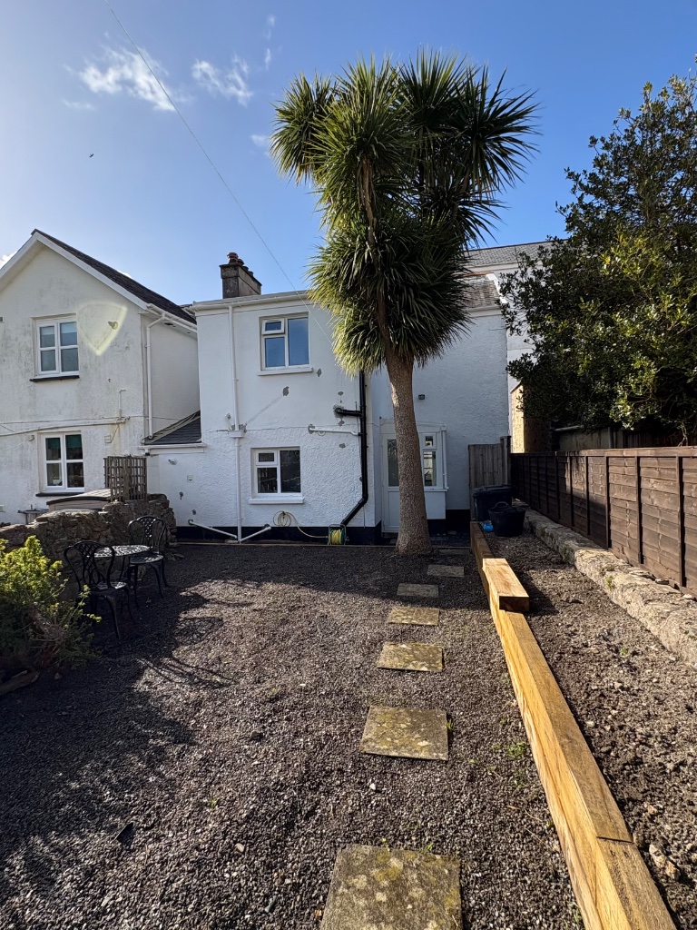 Rear of the cottage with palm tree and garden