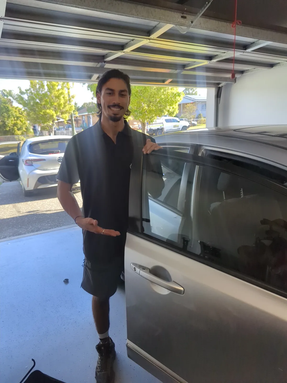 LockOps technician presenting an opened car door in a customer's garage