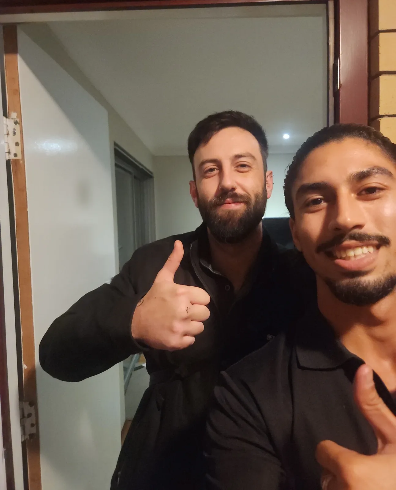 Customer giving a thumbs up with the LockOps technician at his unit door at night