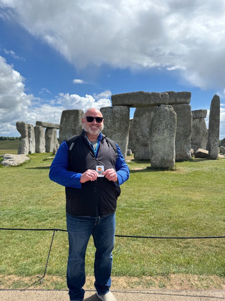 Man holding a duck card in front of Stonehenge