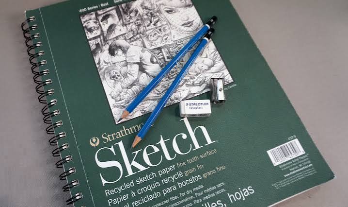Strathmore sketch notebook with a graphite drawing and pencils resting on the cover