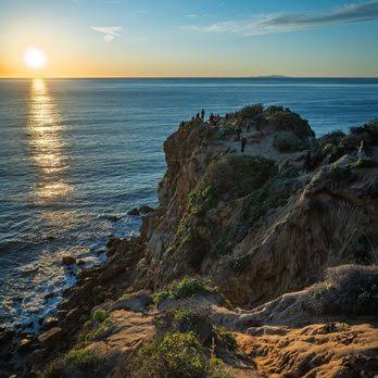 Point Dume overlook — golden hour over the rocky coastal bluff, silhouettes watching the sunset