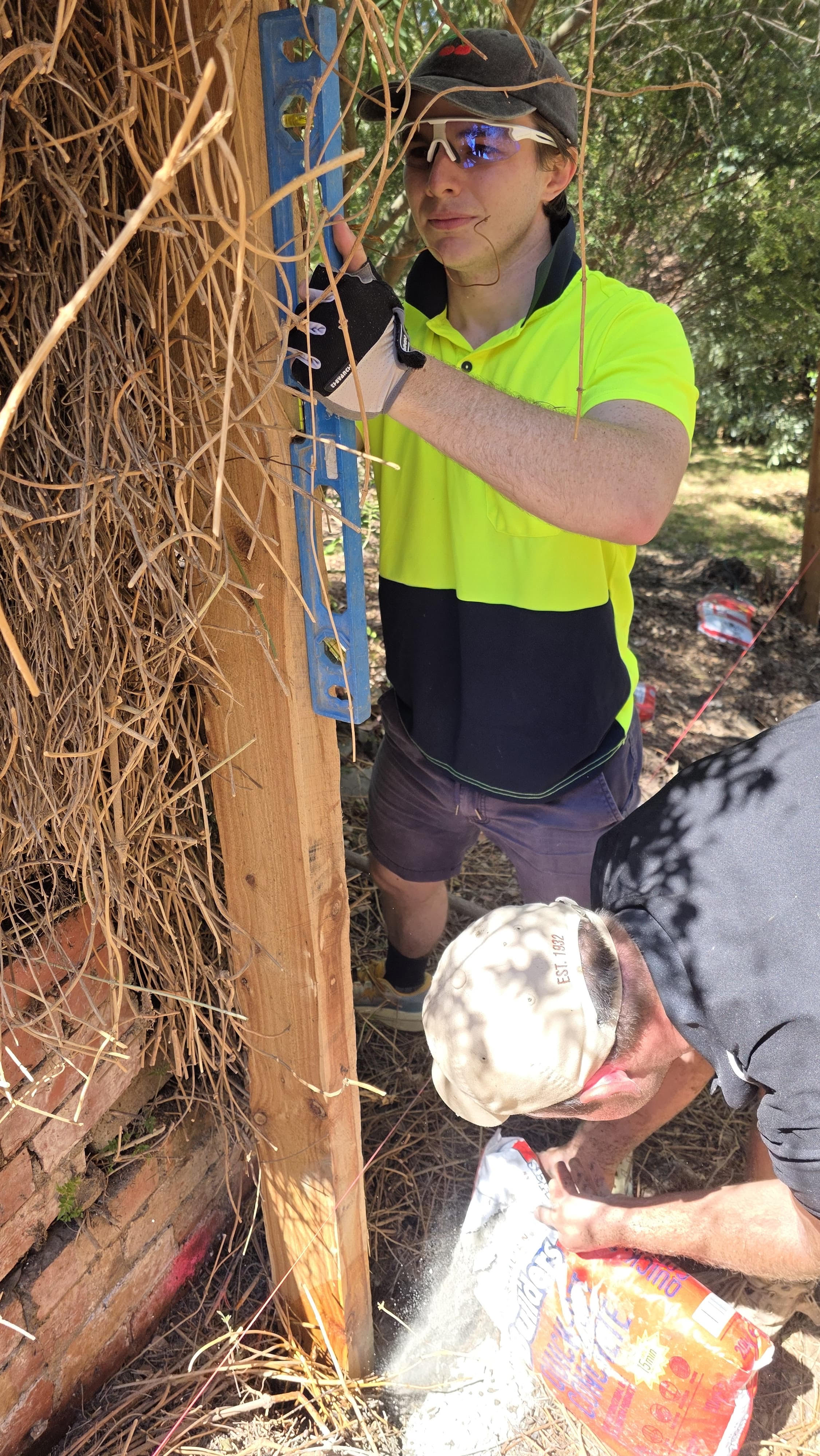 Staff setting fence post