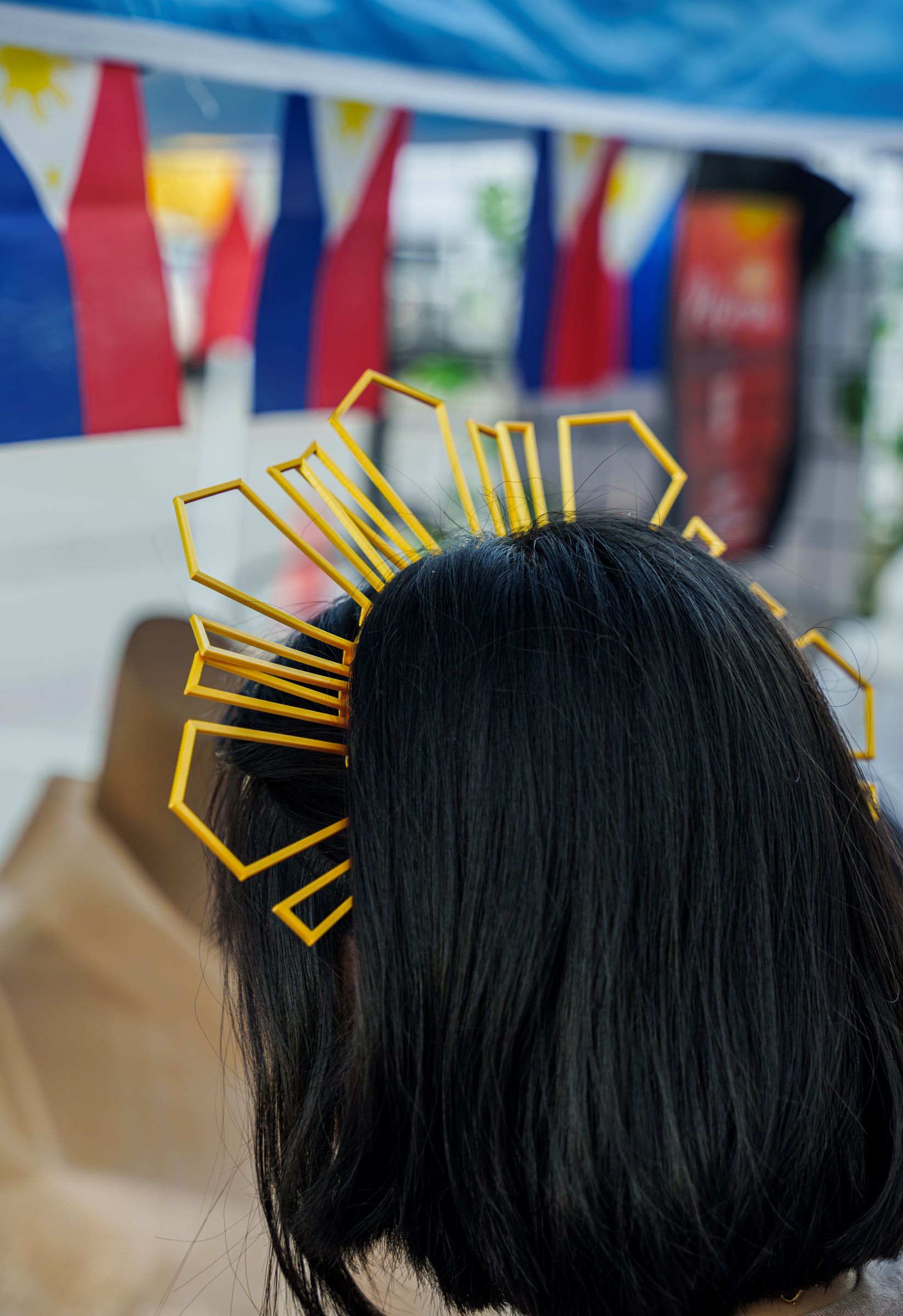 Filipino festival attendee with traditional sunburst hair accessory
