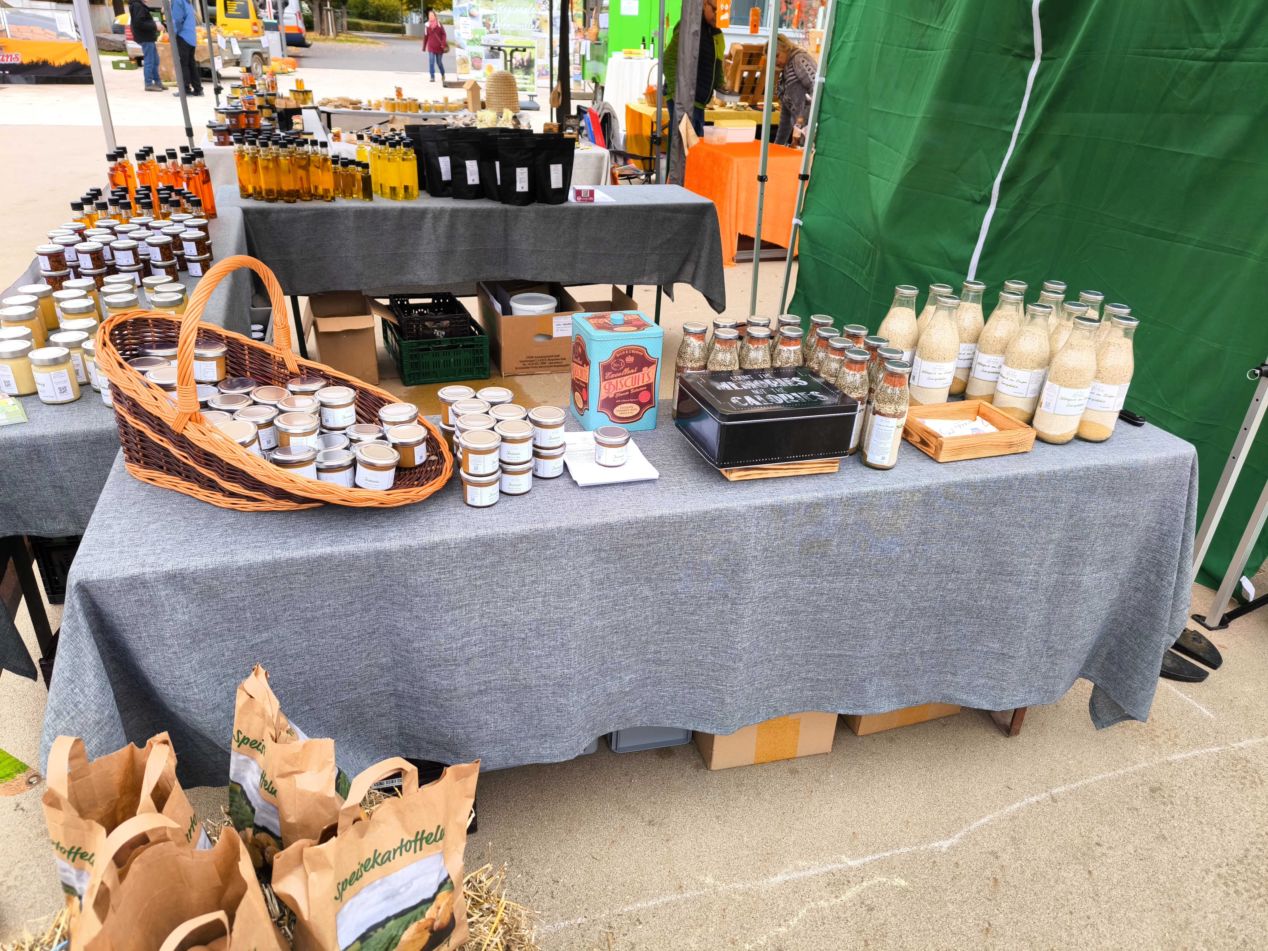 Detailansicht des Bauernhof-Stands auf dem Genussmarkt Eppelborn mit Gläsern, Ölen und Kartoffeln