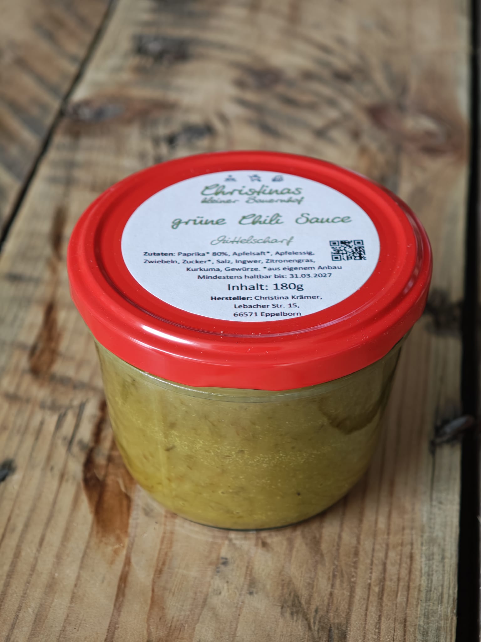 Glas mit grüner Chili Sauce mit rotem Deckel