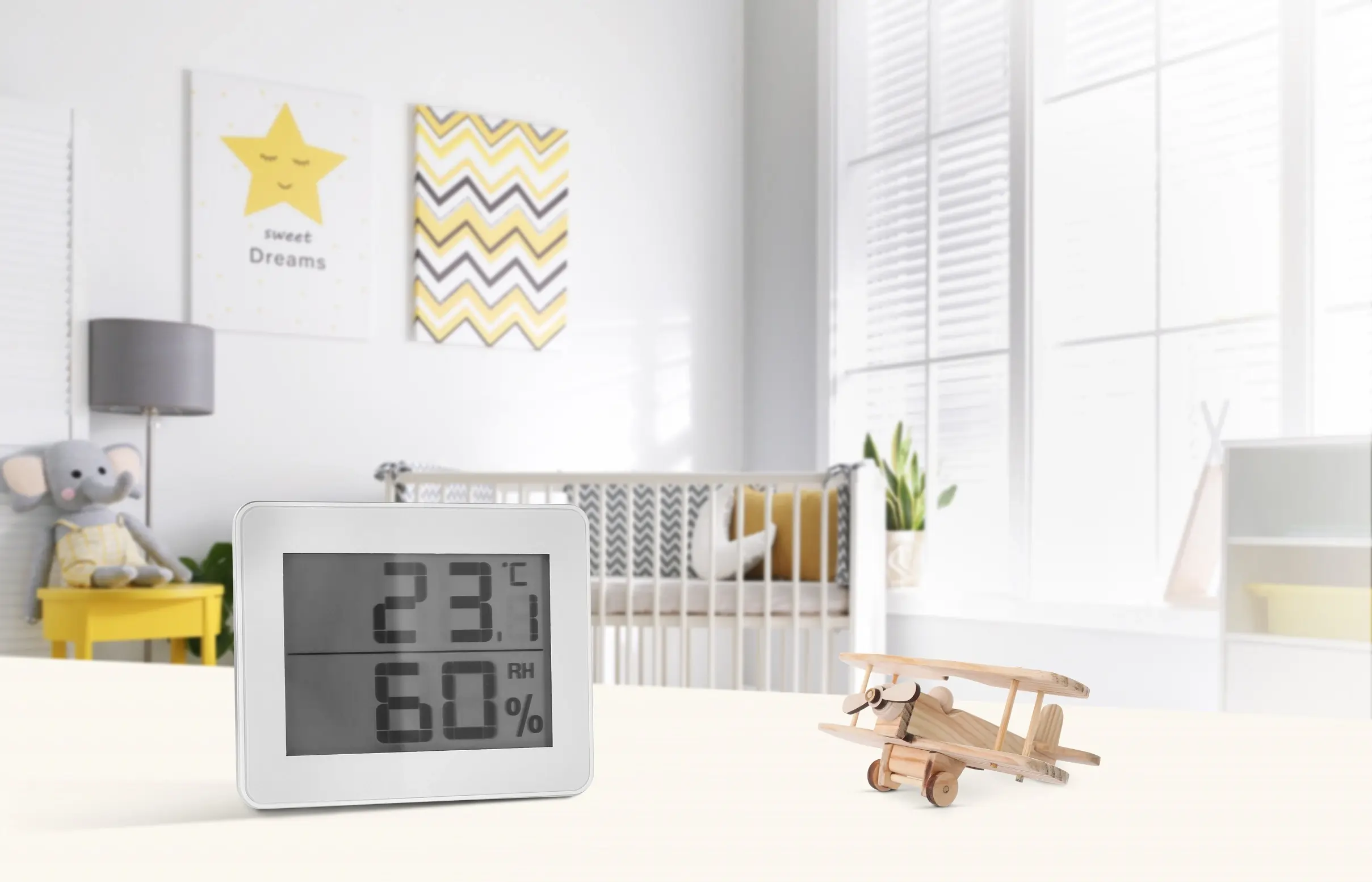Hygrometer und Thermometer im Babyzimmer zeigt 23 °C und 60 % Luftfeuchtigkeit – optimales Raumklima für Babys und Kleinkinder