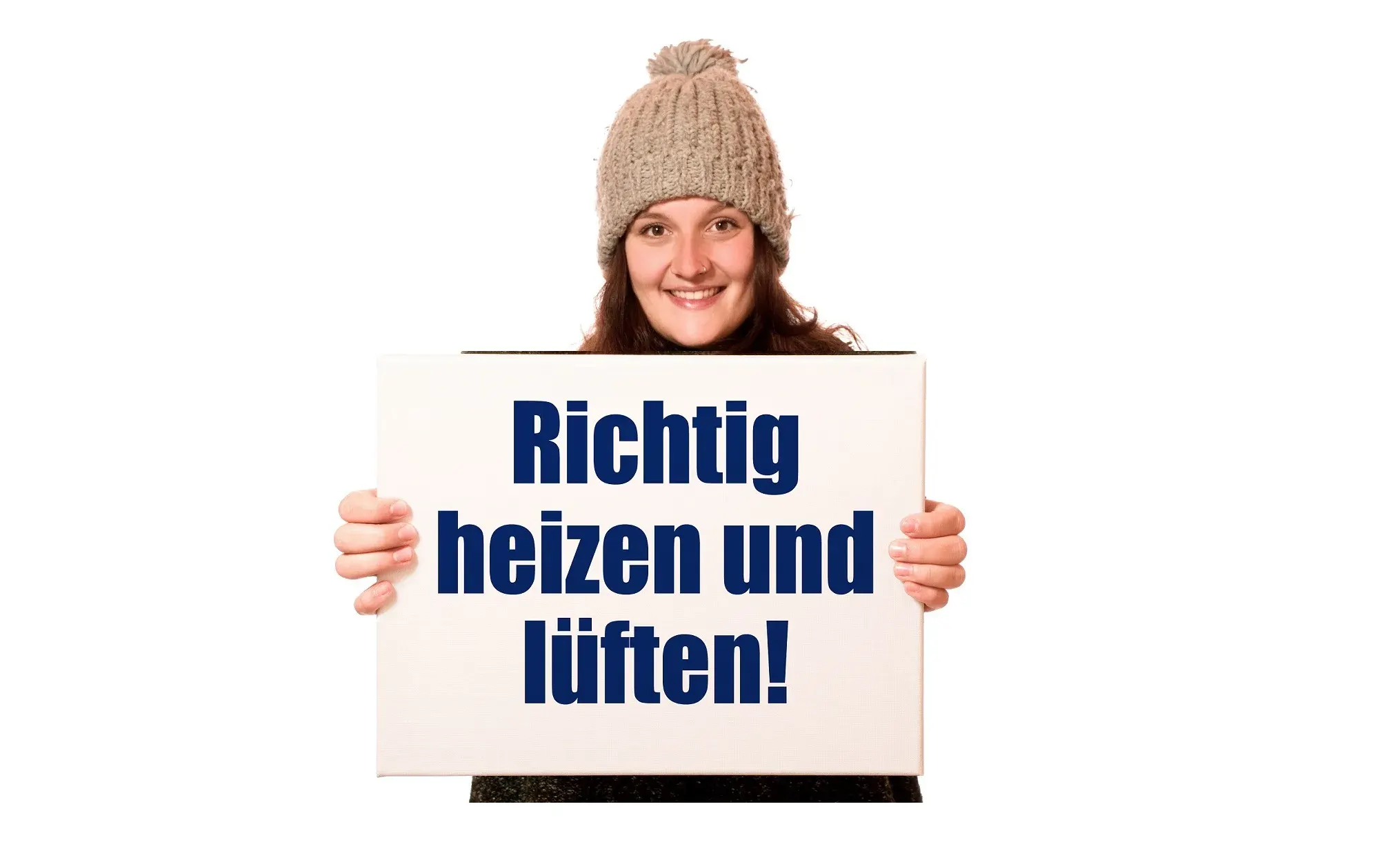 Frau mit Wintermütze hält Schild mit Aufschrift "Richtig heizen und lüften" – Tipp zur Schimmelprävention in Mietwohnungen