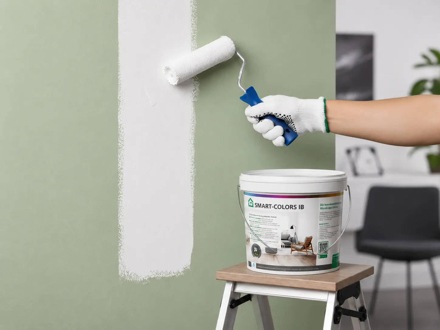 Person trägt Antischimmelfarbe SMART-COLORS IB mit Malerrolle auf eine grüne Wand auf – Schimmelschutz durch spezielle Innenbeschichtung