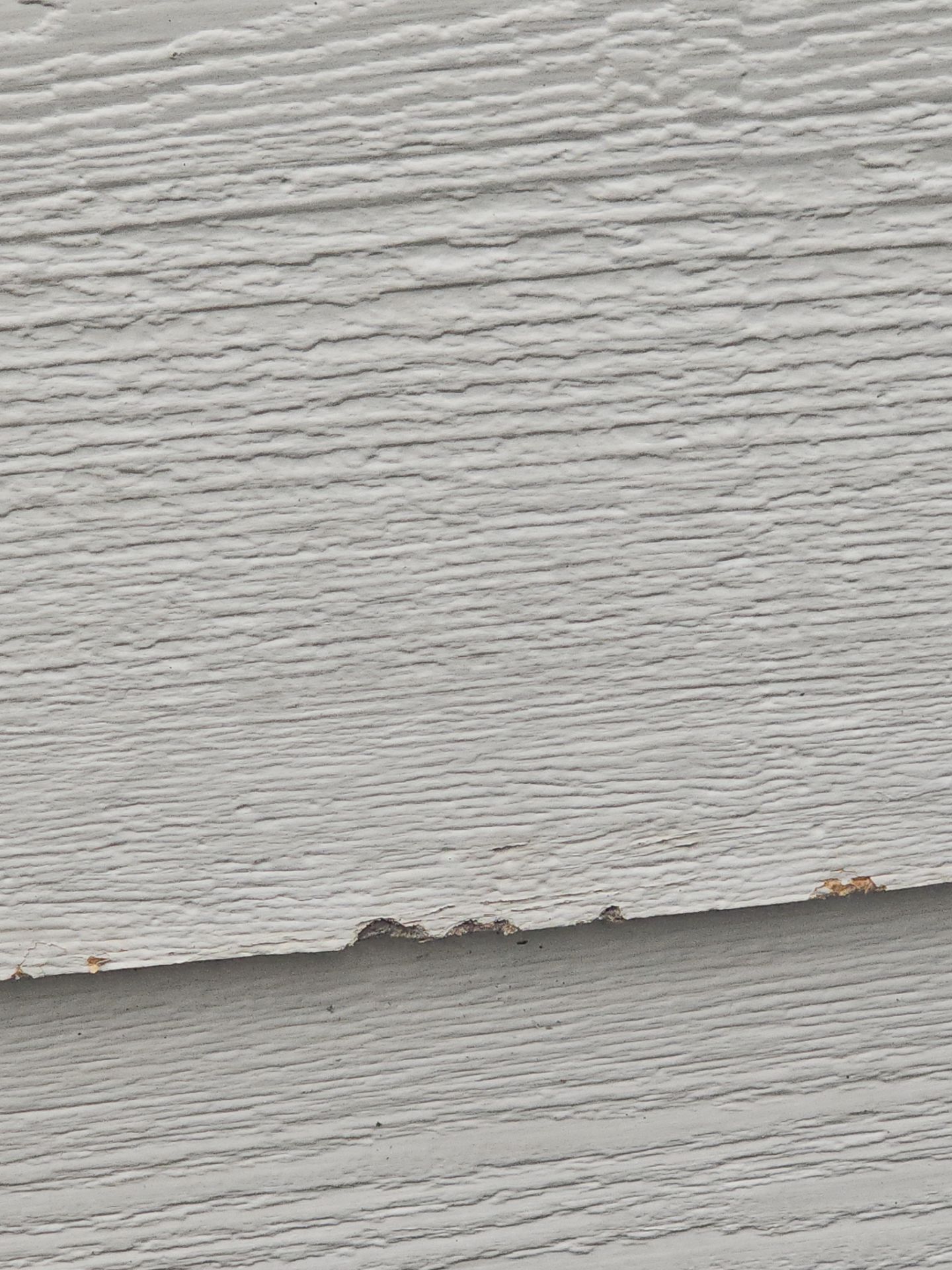 Splintered and chipped siding edge from hail impact in Colorado Springs