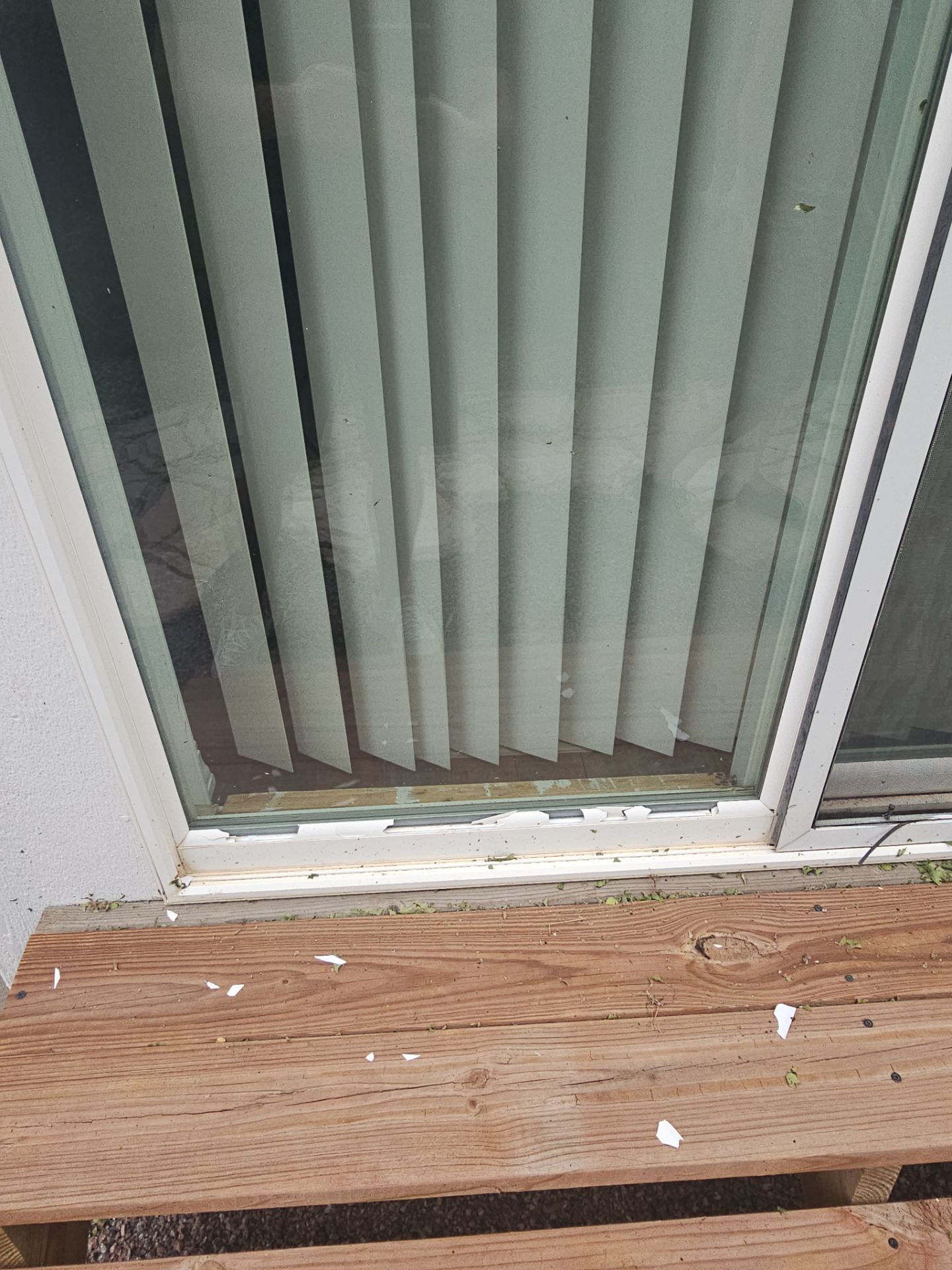 Fractured sliding glass door frame at the threshold from hail damage