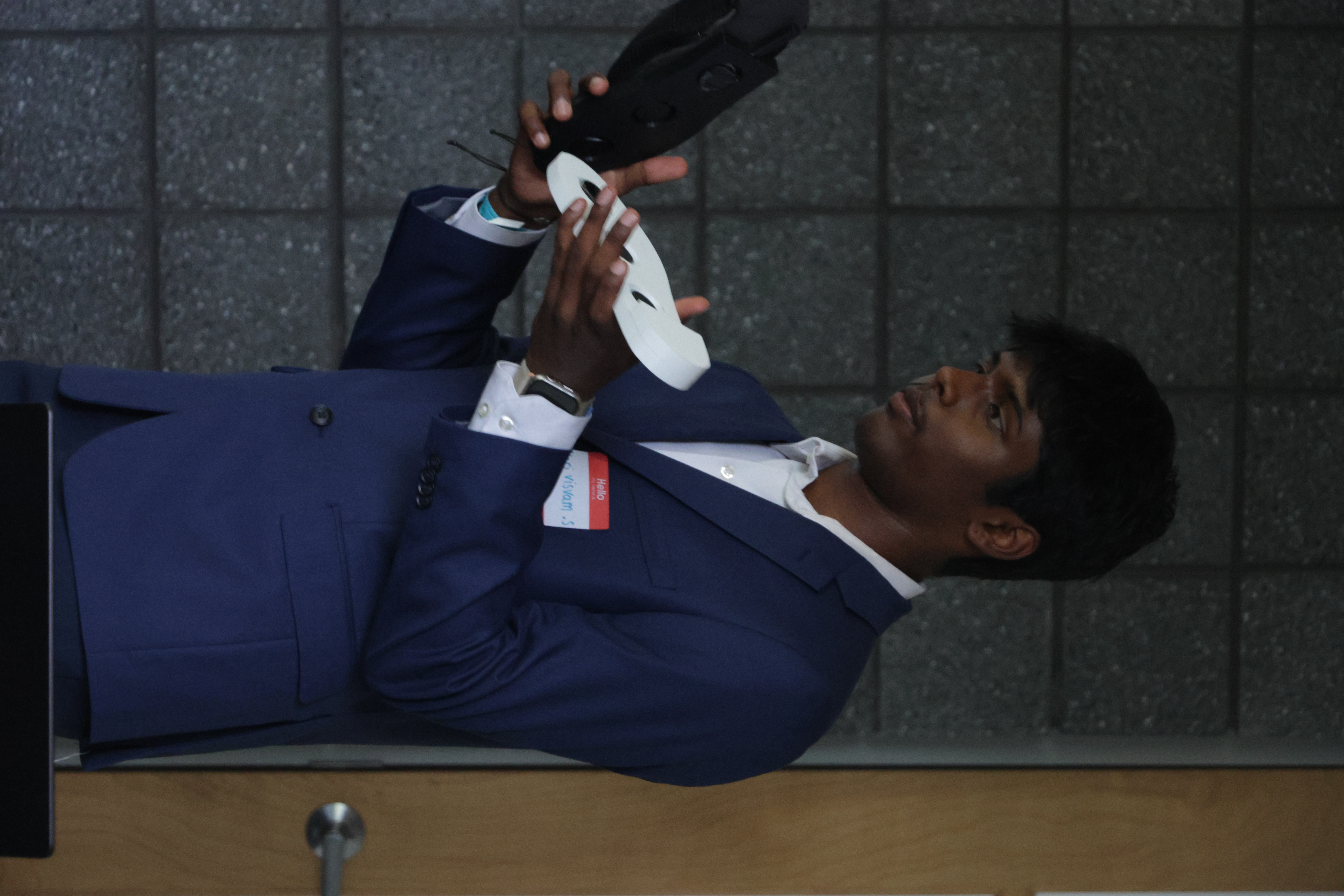 A student in a blue suit holding a prop at Launch Up