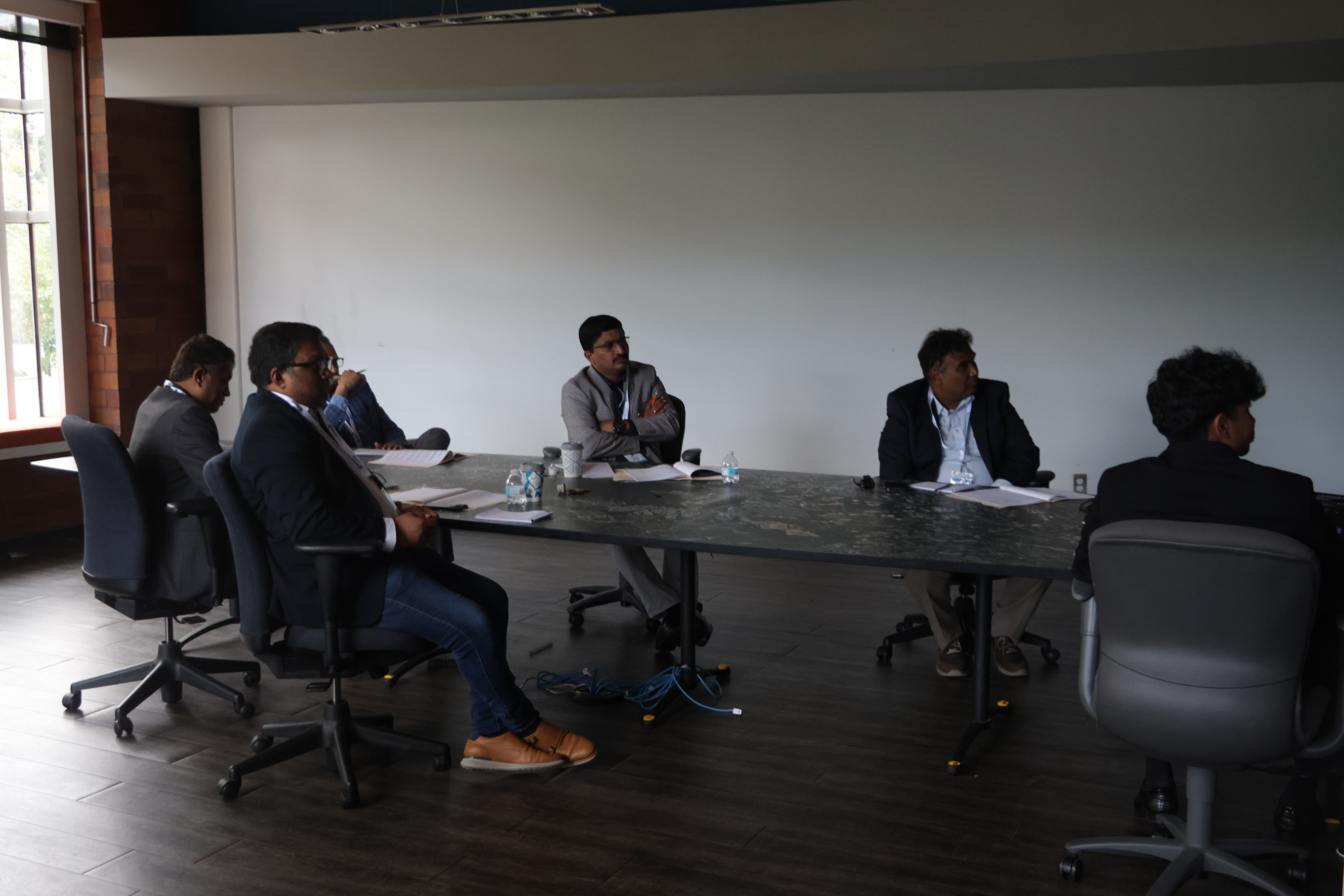 Participants and judges seated around a conference table at Launch Up