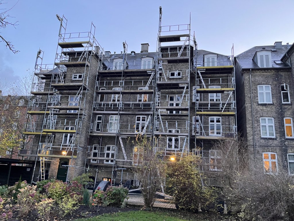 Stillads op ad klassisk ældre etageejendom med hvide vinduer – JB Entreprise facade og vinduesrenovering