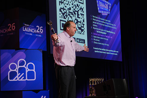 Jim Casey hosting a live Orlando game show corporate event on stage with wireless buzzers and a large projection screen