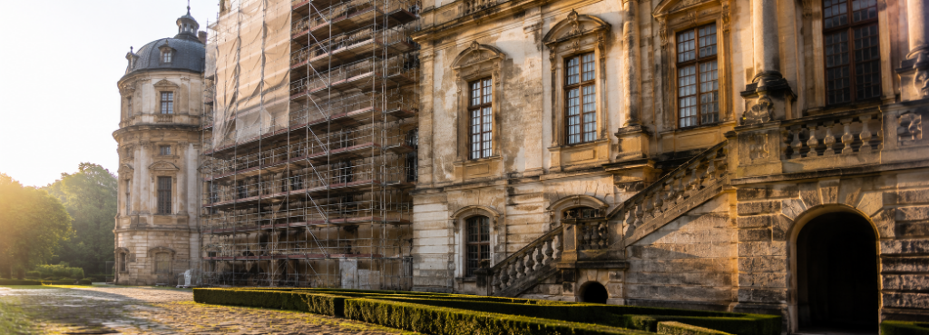 Denkmäler & Historische Gebäude – Denkmalgerechte Fassadensanierung und Feuchtigkeitsschutz Barockes Schlossgebäude mit Einrüstung bei Fassadensanierung – denkmalgerechte Restaurierung historischer Fassadenoberflächen mit Feuchtigkeitsschäden.