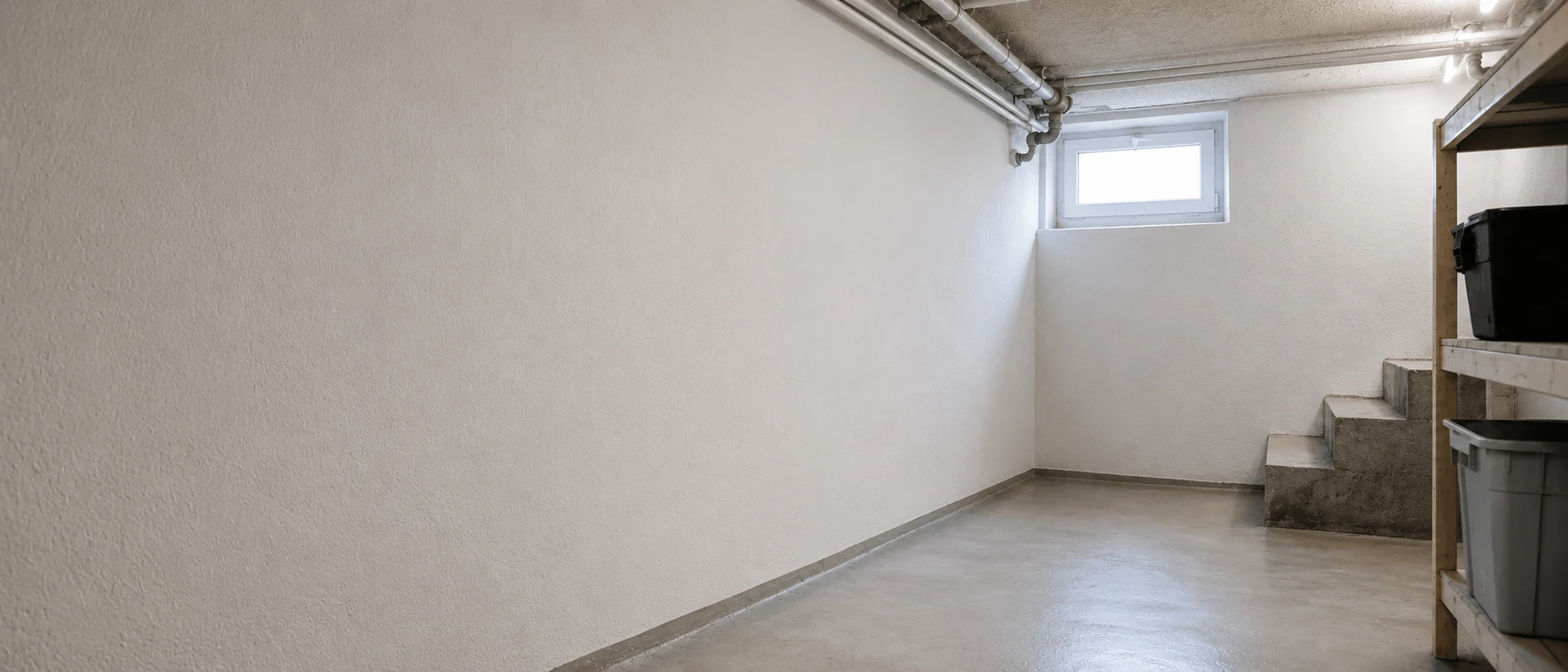 Sauberer, heller Keller nach professioneller Kellersanierung – schimmel- und feuchtigkeitsfreie Betonwände mit Tageslichtfenster und trockenem Fußboden