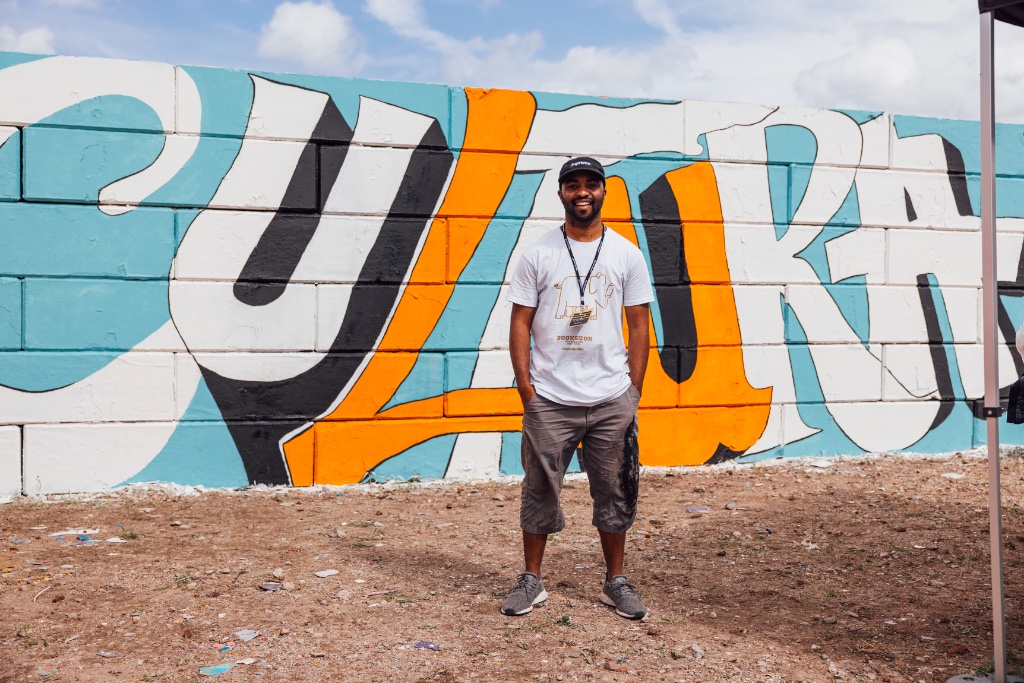 Kevin Rooi in front of mural