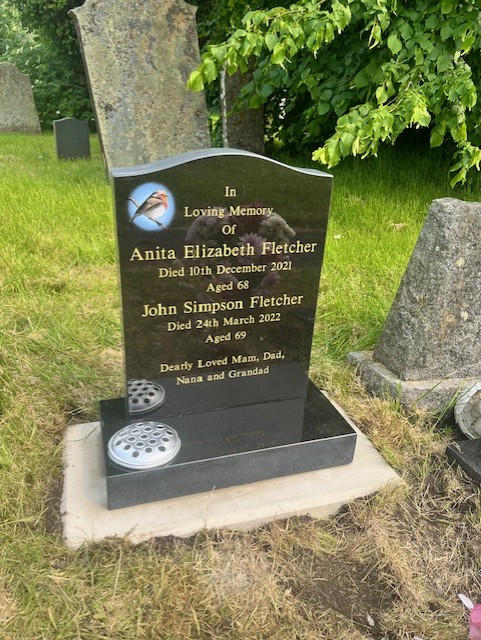 Black granite headstone with robin inlay