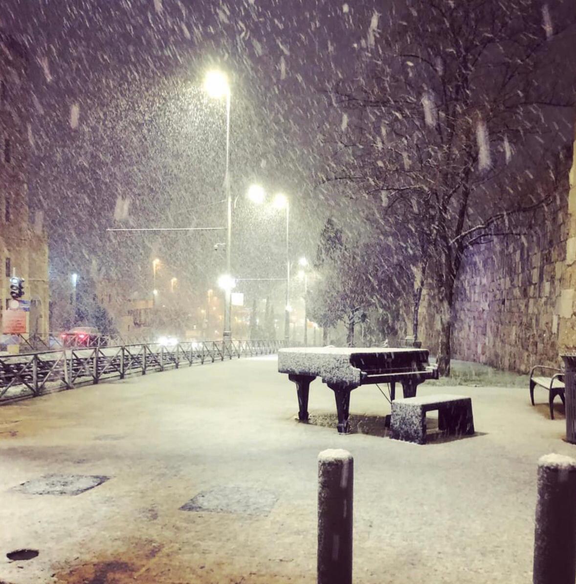 Cadenza outdoor piano covered in snow at night