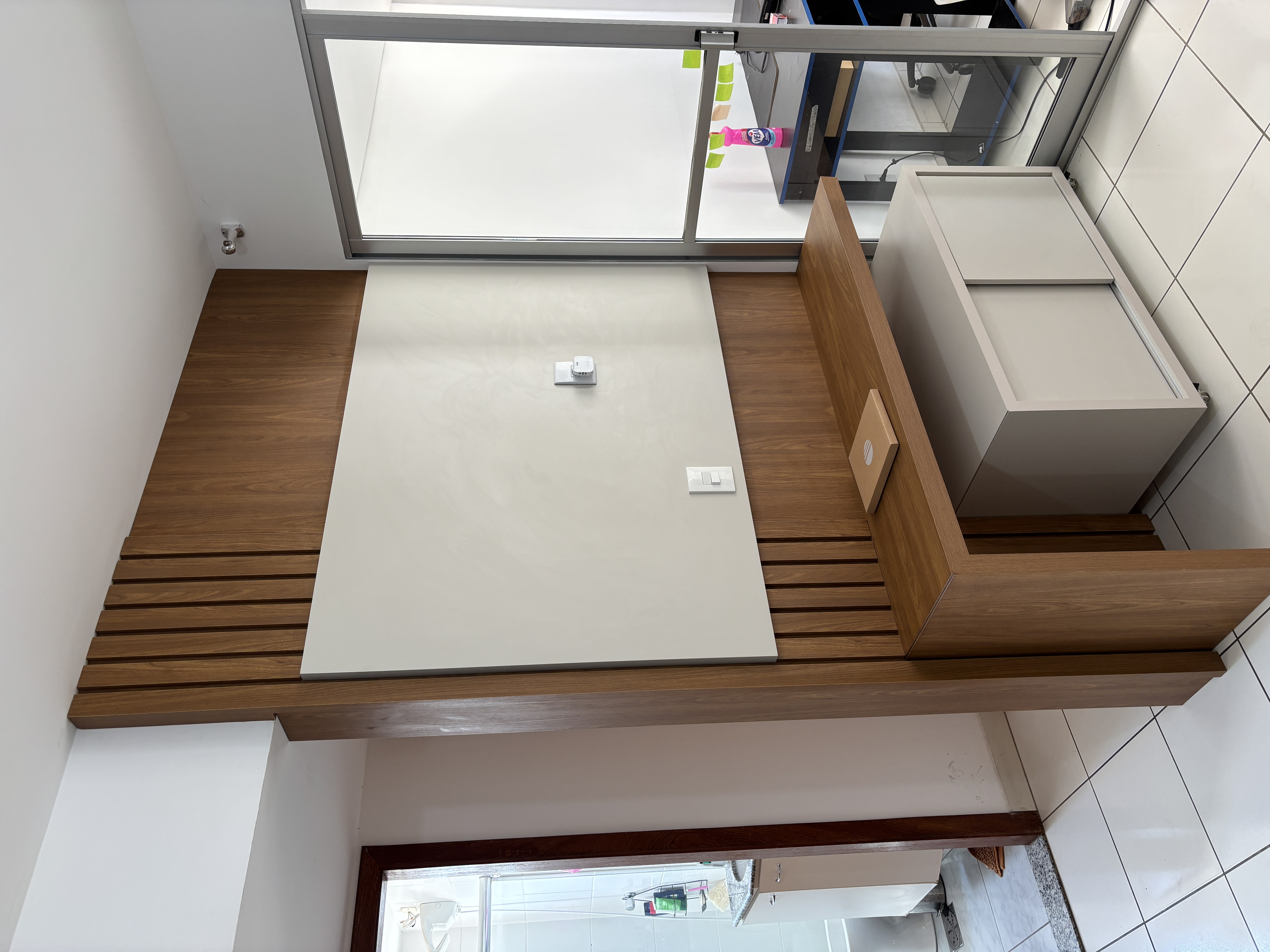 Painel amadeirado com detalhes ripados, superfície clara e rack sob bancada — Ornale Planejados