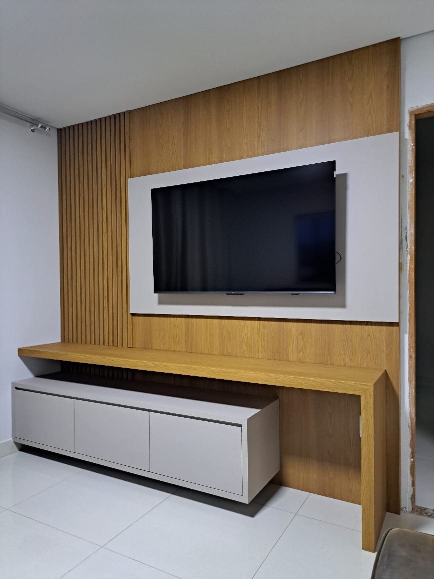 Painel de televisão amadeirado com ripado lateral, moldura clara e rack planejado — Ornale Planejados