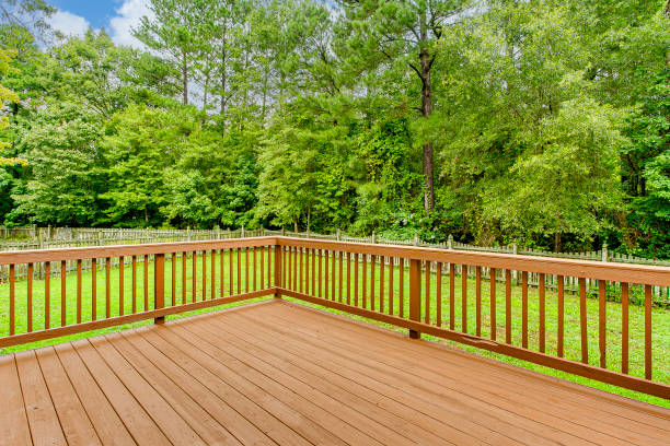 Custom wood deck with railings overlooking a green yard