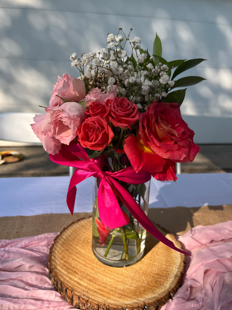 Floral centerpiece with roses on wood slab
