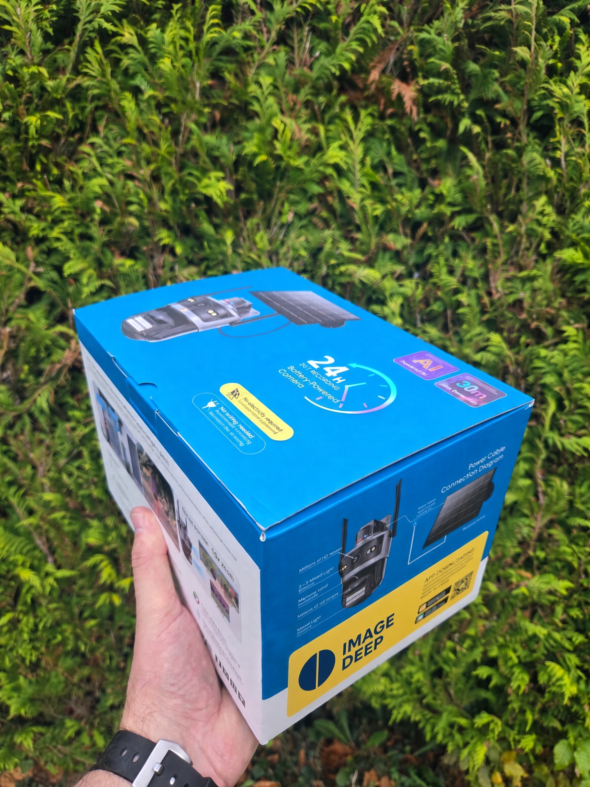 HoundLight-Verpackung in einer Hand: KI-Kamera mit Solarpanel, 24/7-Aufzeichnung, ohne Verkabelung und Strom