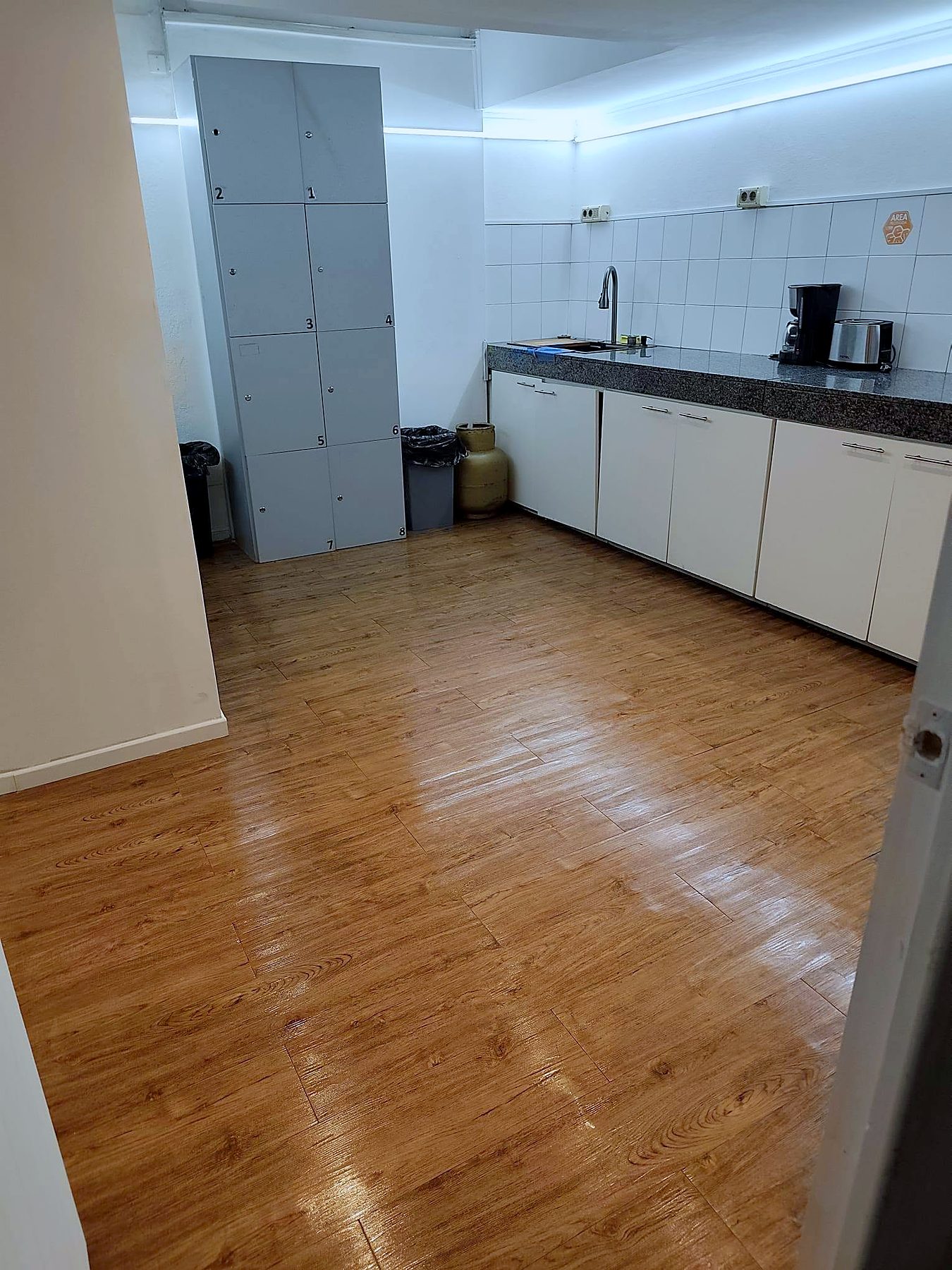 Cocina compartida con mesada de granito, lockers y piso de madera