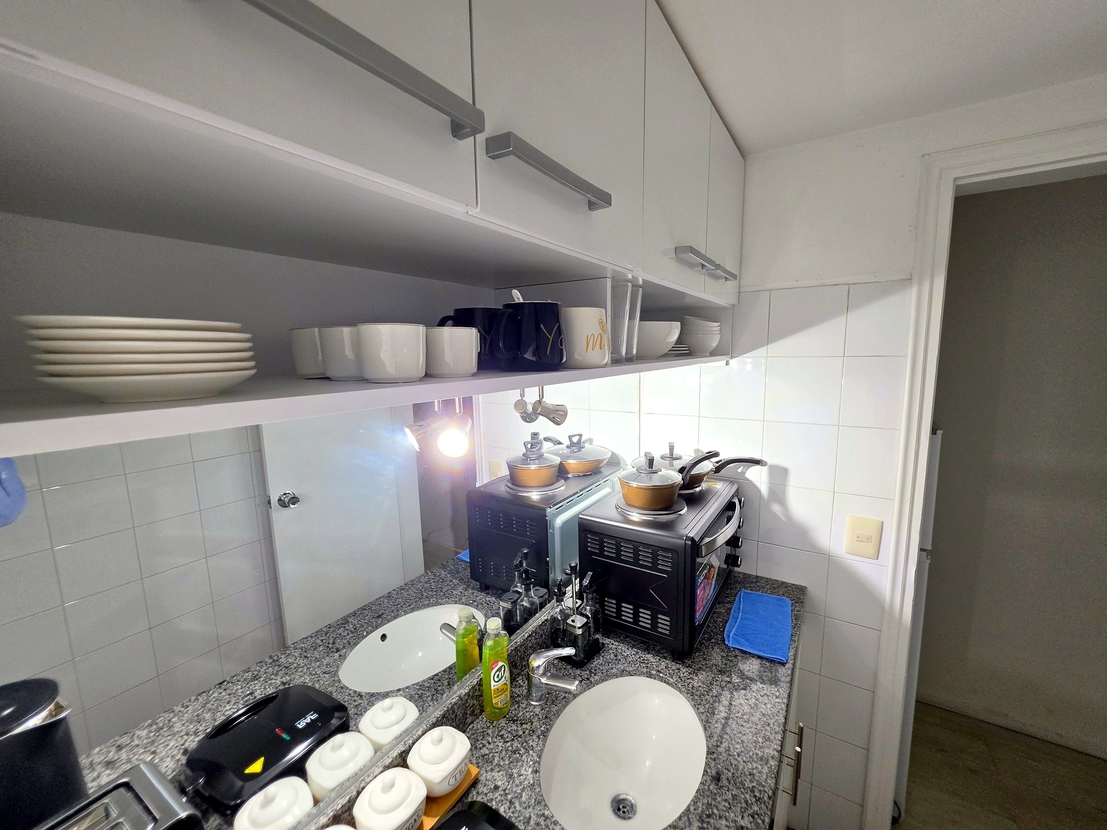 Kitchenette completa con alacenas, vajilla y anafe